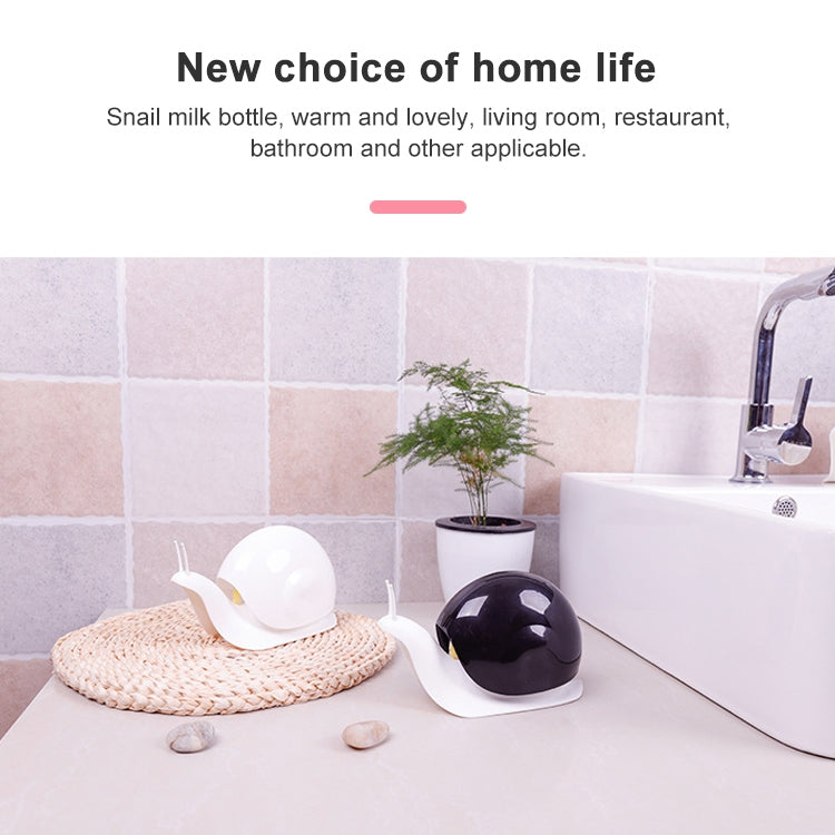 Snail-shaped sanitizer dispenser with black shell dome and white base beside sink area