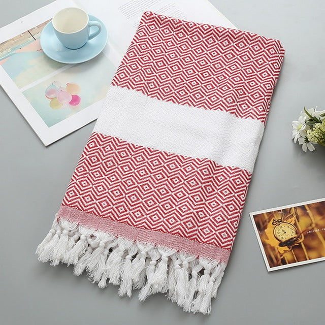 Cotton bath towel with red zigzag pattern, white band, and tassel fringe