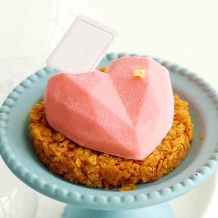 Heart-shaped pink silicone mousse or cake portion on a plate