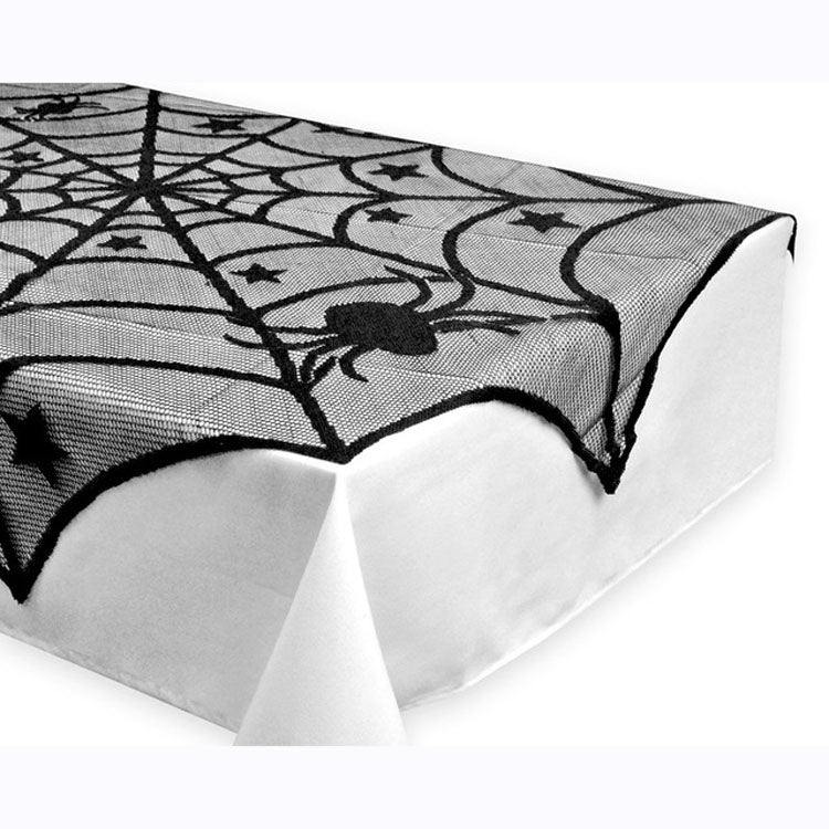 Corner close-up of black spider-web lace tablecloth with stars and spider motif