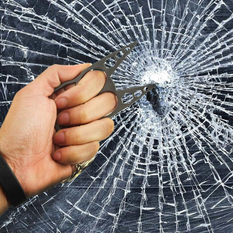 Black cat-face double finger buckle pressed against cracked glass