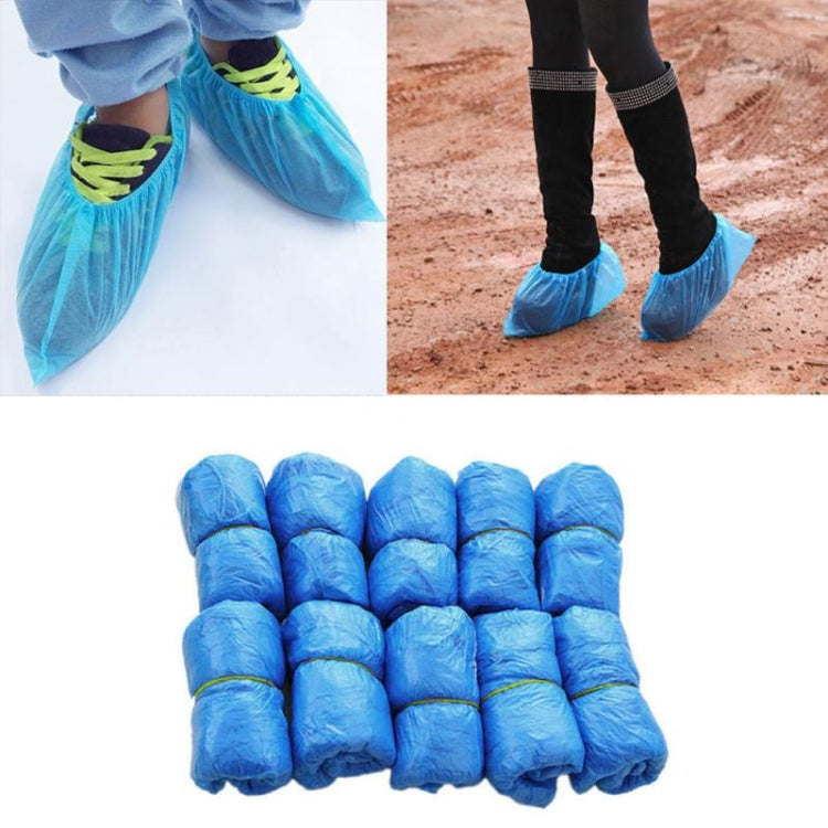 Disposable blue shoe covers on shoes outdoors, plus a bundle of covers