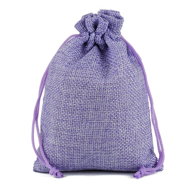 Purple jute linen drawstring gift bag with gathered top and tied strings.