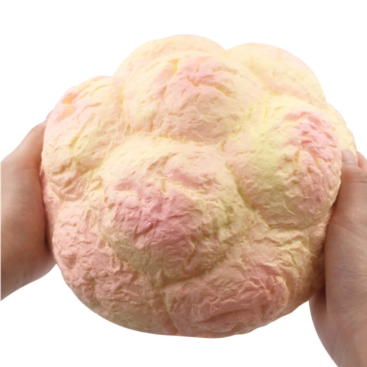 Large cream puff scented squishy in hands, cream and pink pastel close view