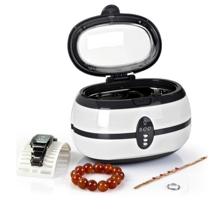 Ultrasonic jewelry cleaner with open lid, white-and-black striped body; bracelet and accessories