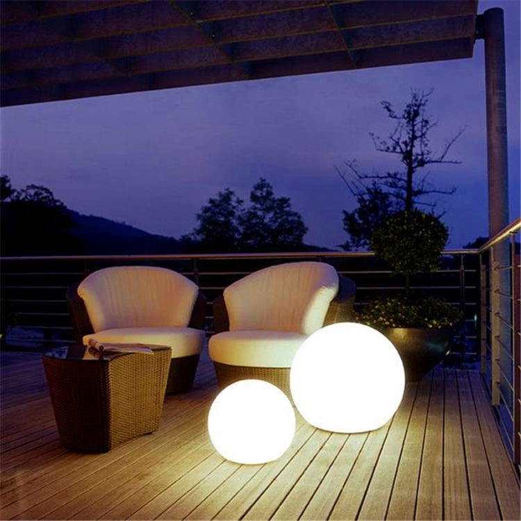 LED globe floor lamp with two round white lights on a dark outdoor wooden deck