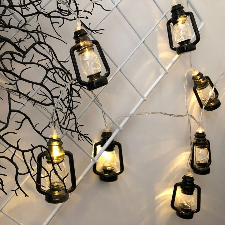 Black kerosene-style lantern LED string lights with warm glowing bulbs, hanging arrangement