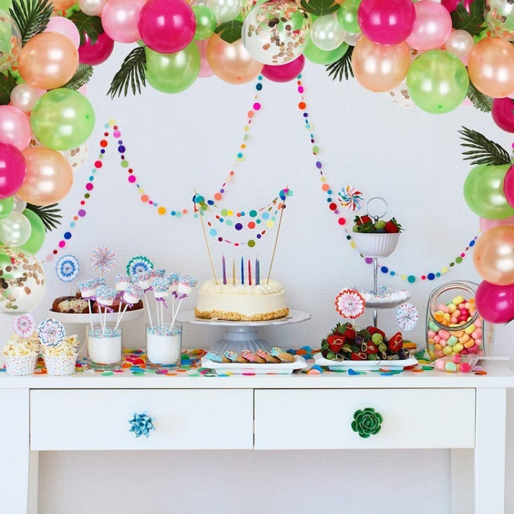 Tropical balloon garland frame with pink, green, and confetti balloons above dessert setup