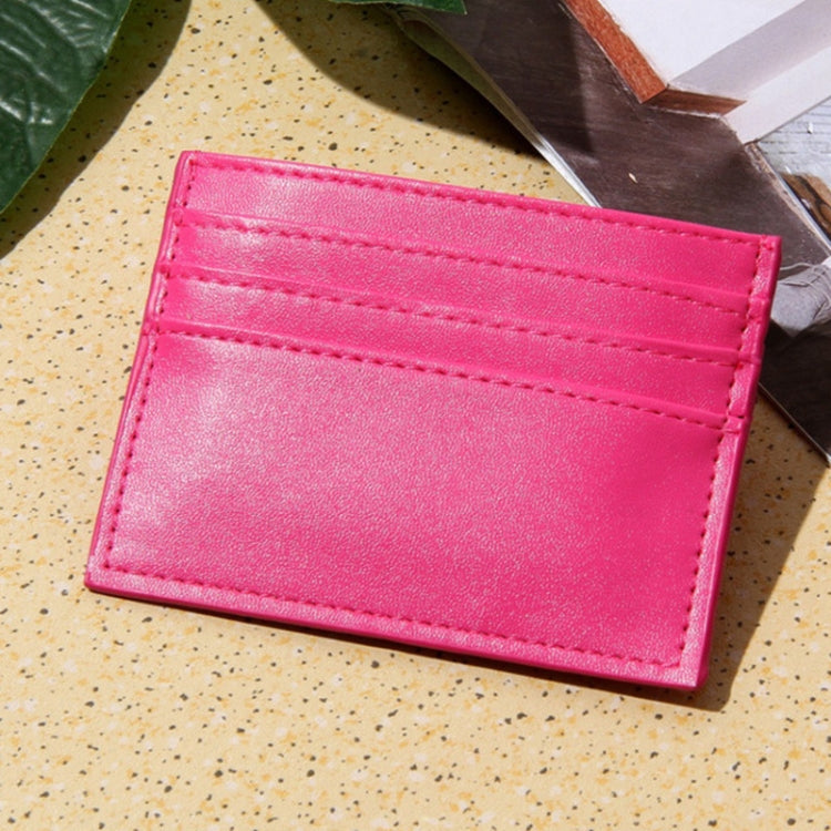 Pink card holder with multiple card slots and stitched border detail