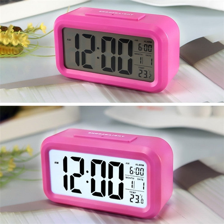 Backlit electronic alarm clock, pink case, digital time 12:00 and temp 23.3°C