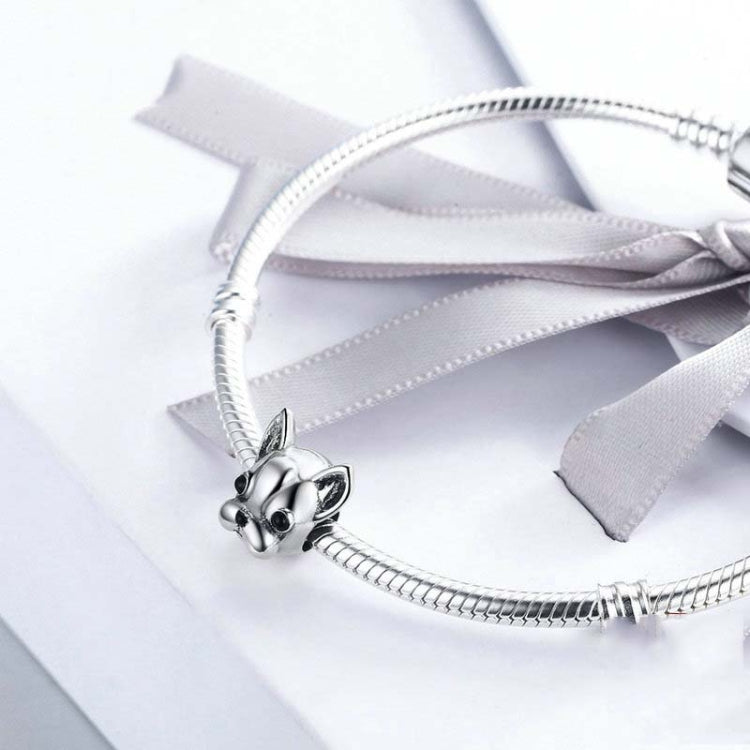 Bulldog face charm bead on a silver snake chain bracelet with a light ribbon bow
