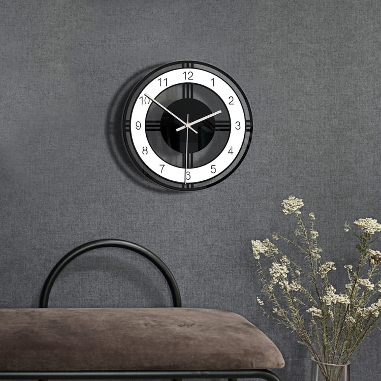 Round wall clock with black face, white numbers, and minimalist silver hands