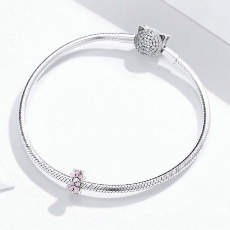 Silver snake bracelet featuring a pink enamel flower charm bead near the clasp