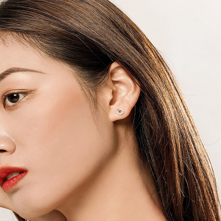 Small round zircon stud earrings on the ear, platinum plated