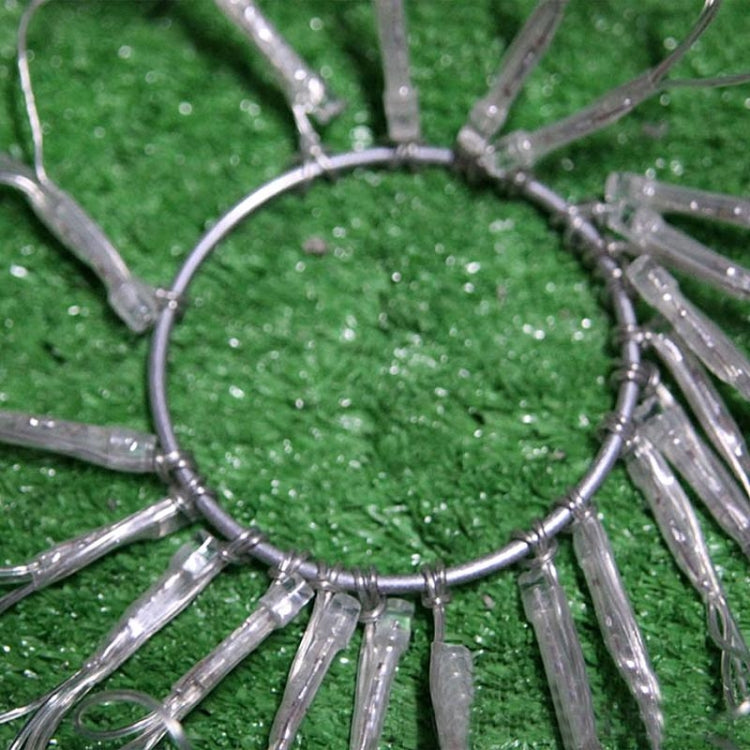 Close-up of metallic spider-web LED string lights on green turf