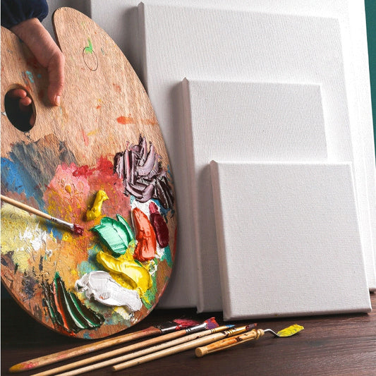 Wood-framed canvas panel with blank surface, paint palette nearby