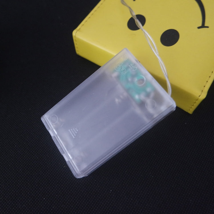 Battery-powered LED controller with clear battery holder and connected string light wire