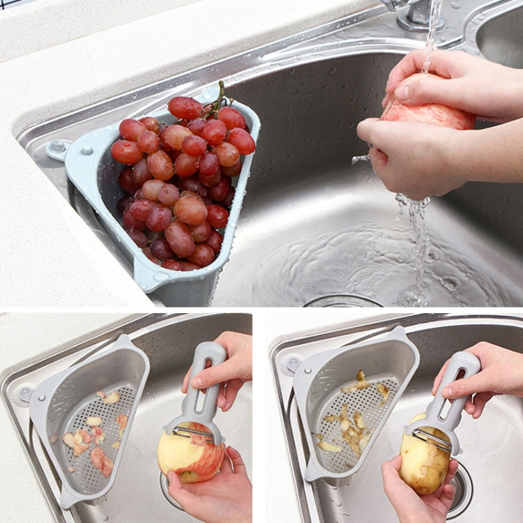 Light blue triangular sink drain rack basket holding grapes and kitchen scraps
