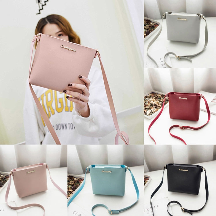 Pink crossbody zipper bag shown on model with adjustable long strap