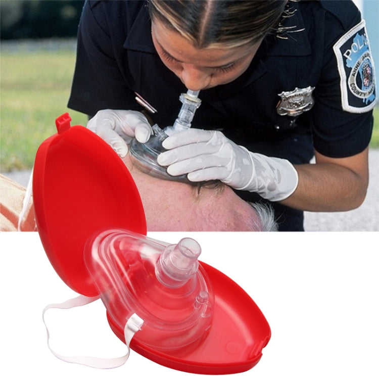 Red CPR mask with clear one-way valve placed on face and secured with strap