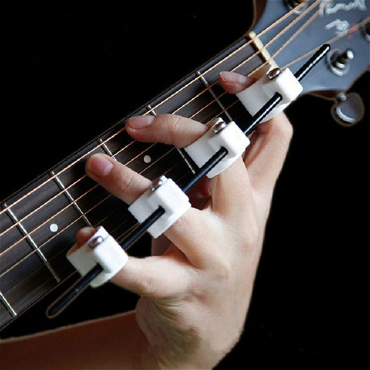 Four-finger finger expander on guitar fretboard with white ring pads and black bars