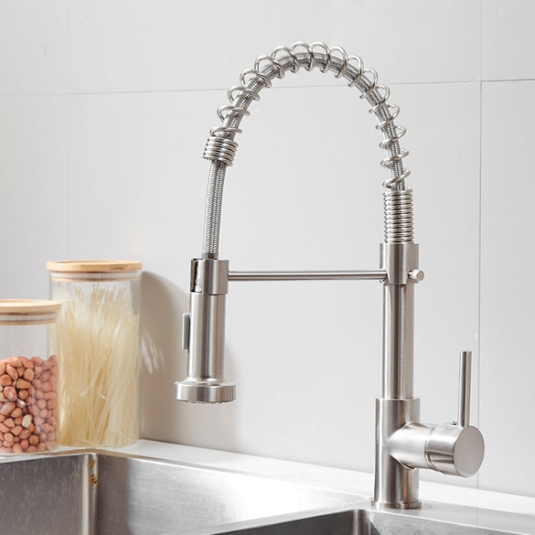 Chrome kitchen faucet with two lever controls and flexible hose at sink