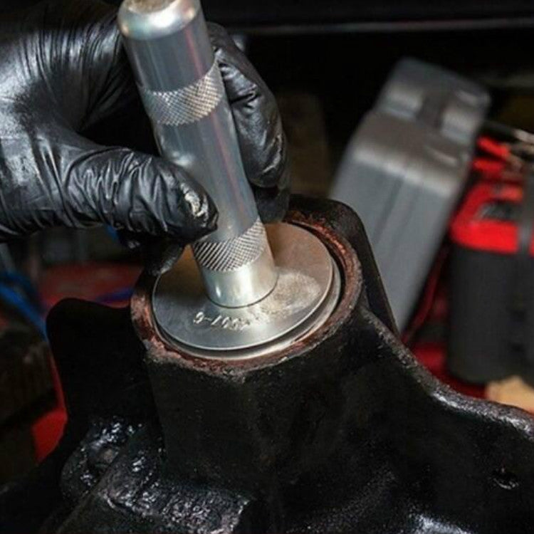 Bearing installation tool pressing a bearing pad onto a metal shaft