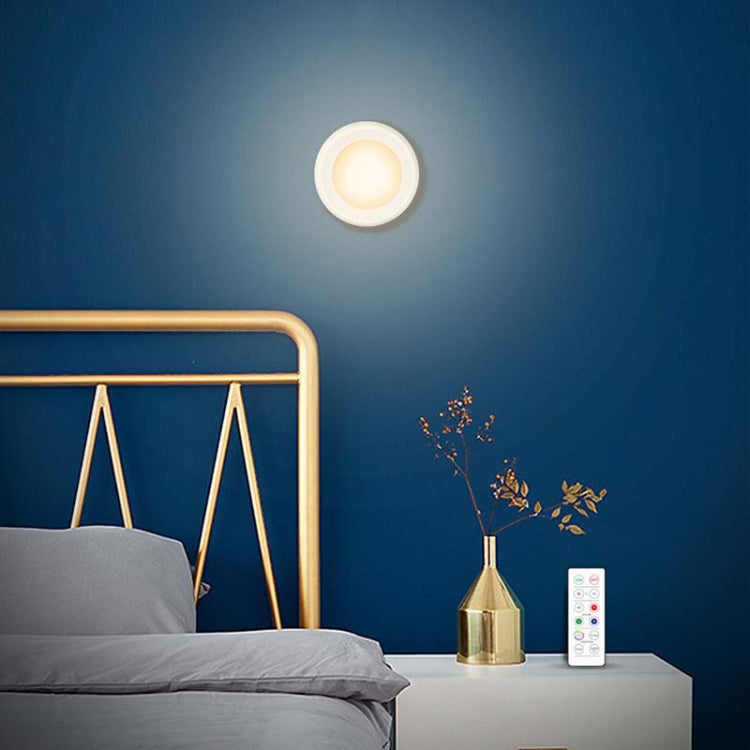 Round LED night light on ceiling with remote control on bedside table