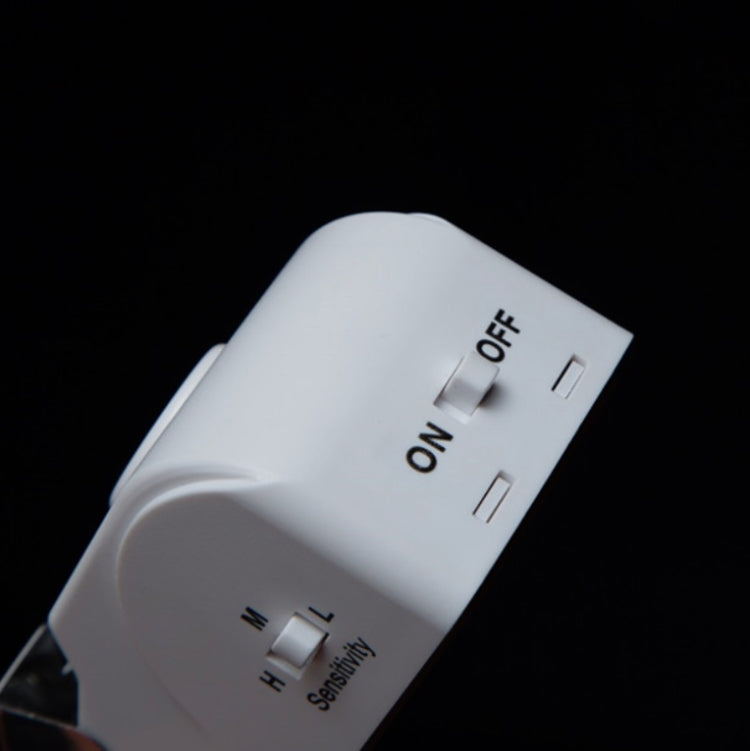 Close-up of ON/OFF switch and sensitivity dial on white smart door block anti-theft device