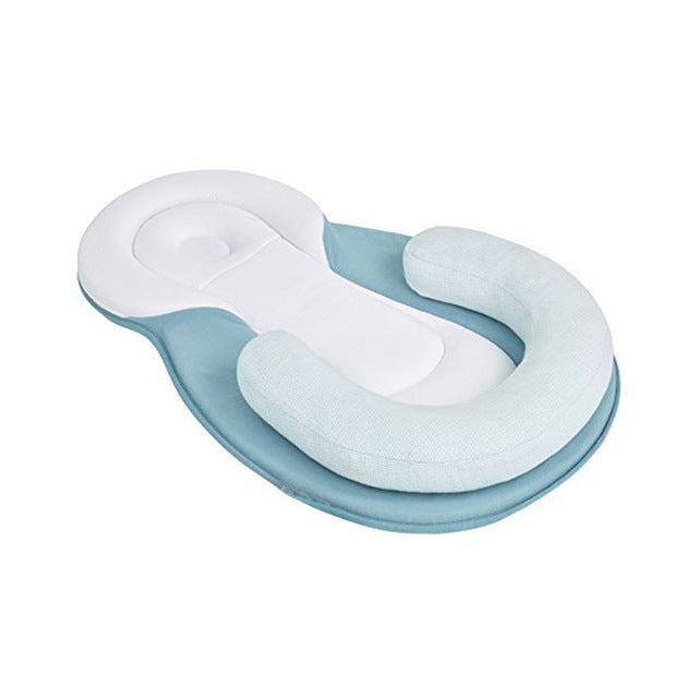 Blue infant sleep positioning pillow with contoured head dip and cushioned side bolsters