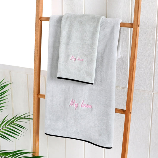 Gray bath towel with “My love” embroidery and dark border, folded on a rack