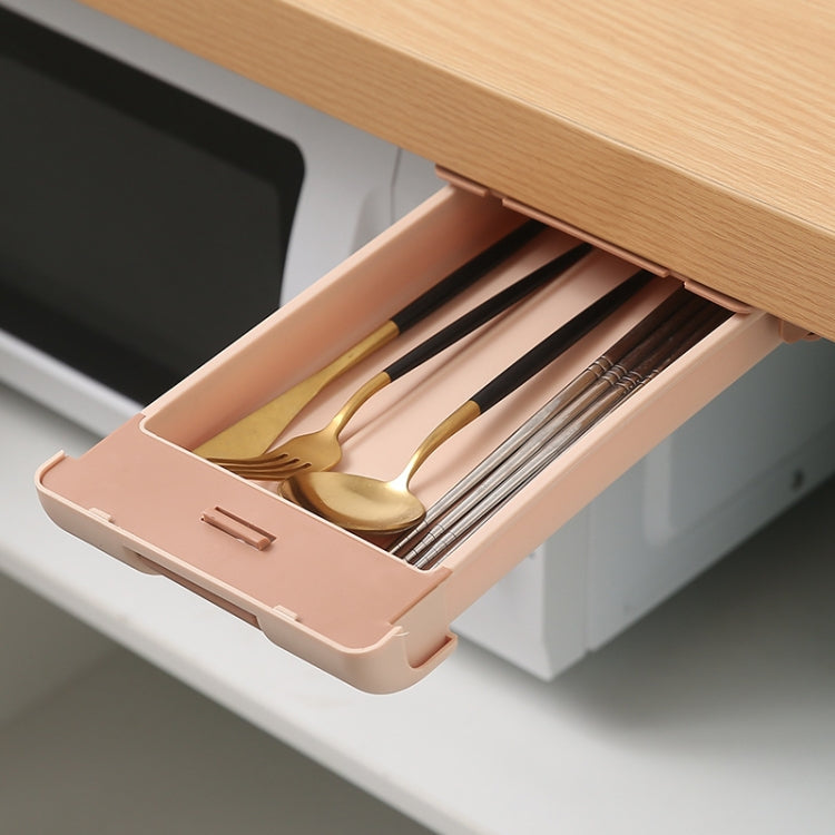 Pink under-desk storage box open with pens, pencils, and office tools inside.