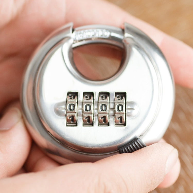 Hand holding round stainless steel combination padlock with four digit code wheels