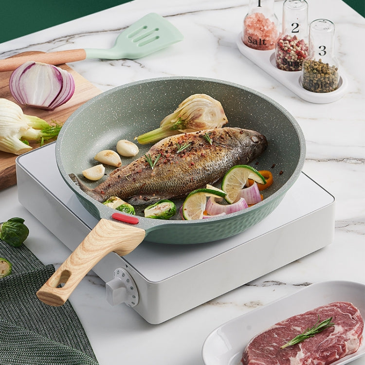 Green non-stick frying pan with wooden handles and speckled finish on induction cooker