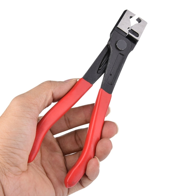 Hose clamp pliers in hand, red handles and black locking jaw