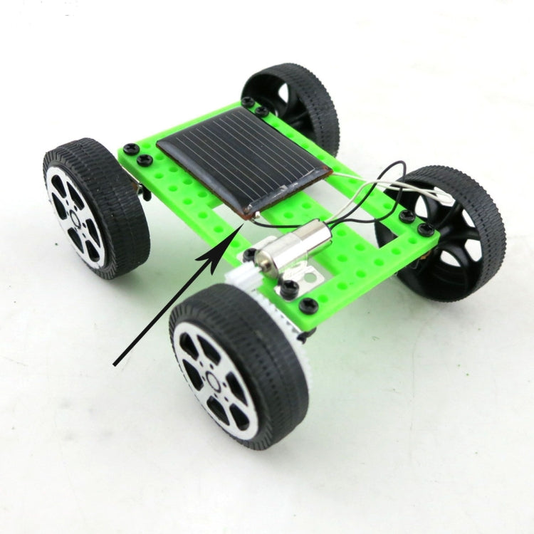 Solar-powered DIY toy car with green chassis, black wheels, and solar panel