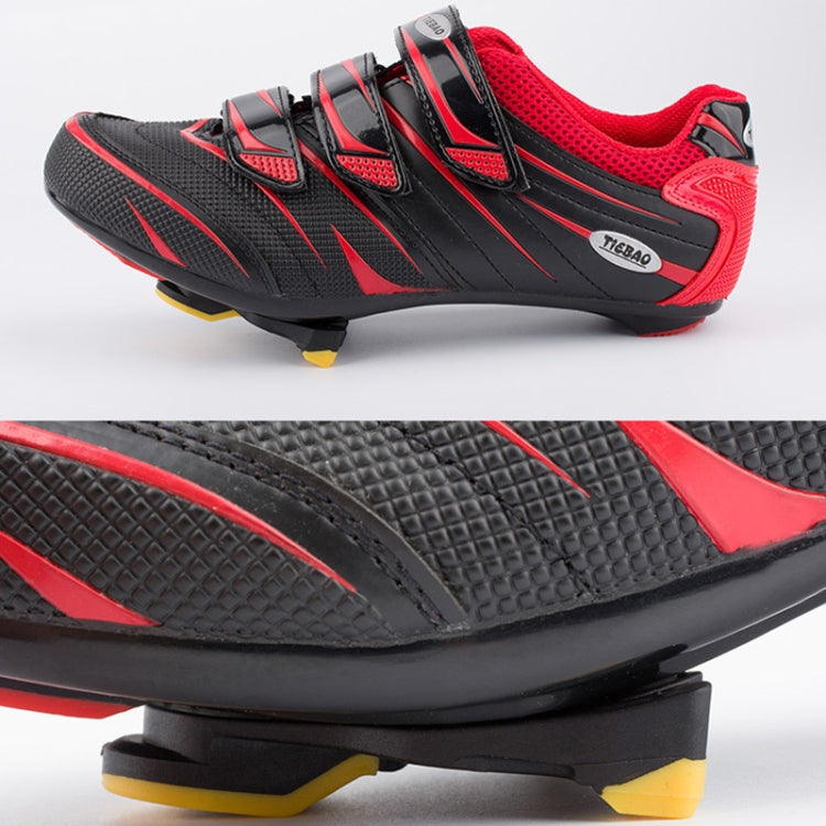 Red and black road bike shoes with cleat and textured sole, close-up