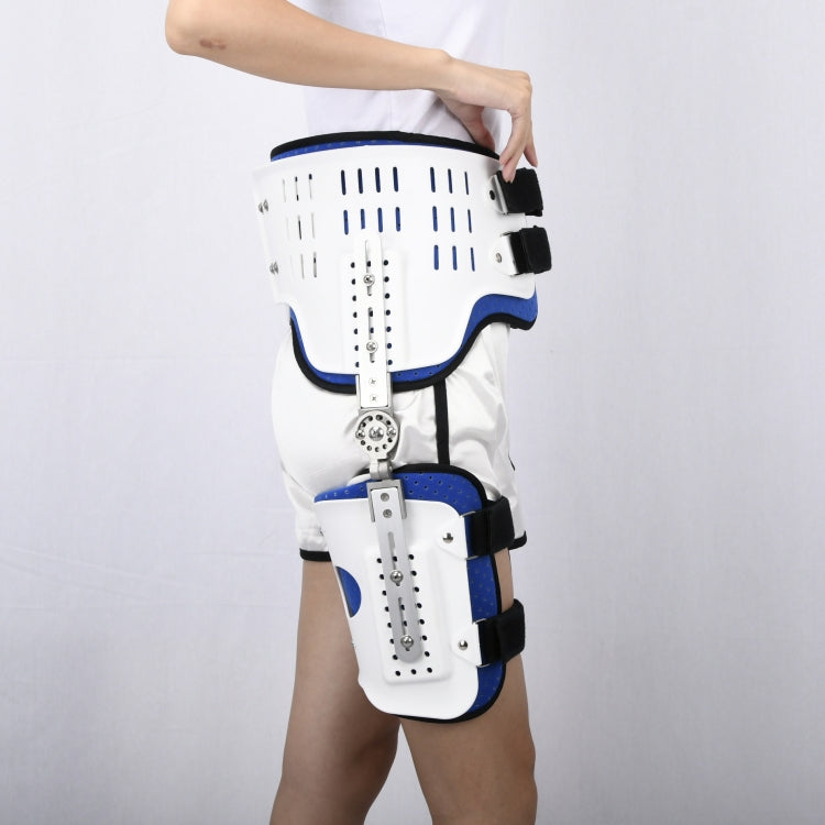 Hip fixation brace with white rigid shell, blue padding, and black straps, worn on leg