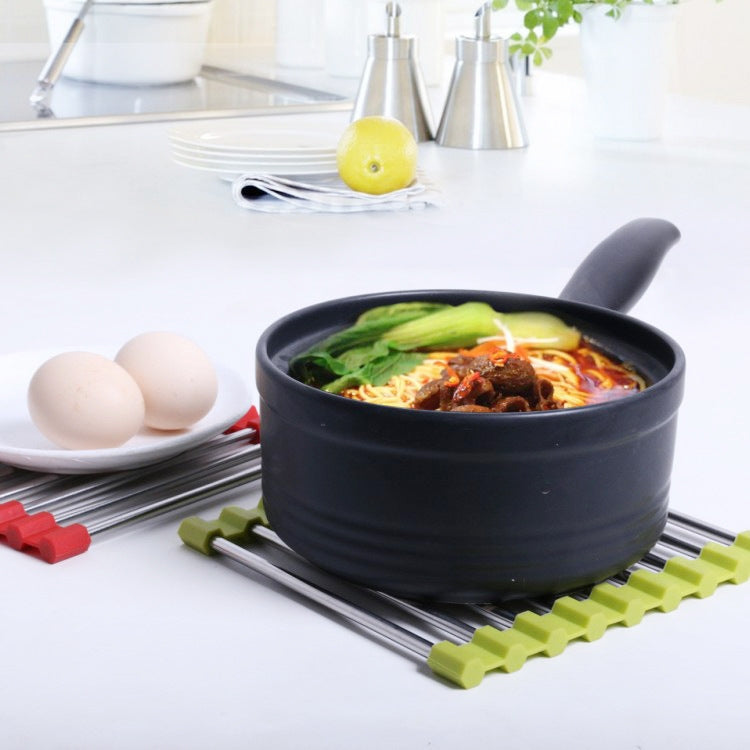 Stainless steel pot mat with lime green non-slip strips under a hot pot