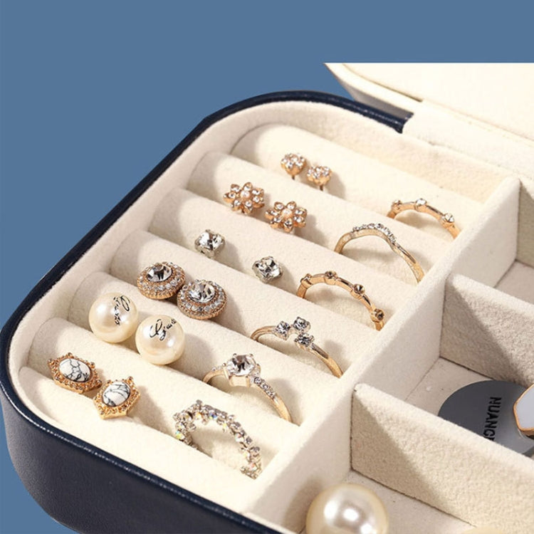 Open jewelry storage box with ring compartments and flannel dividers, navy outer frame