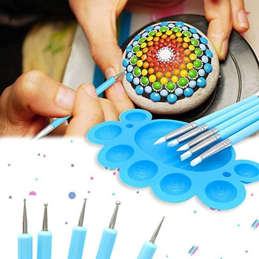 Mandala dotting tool tips and blue pens creating a colorful circular pattern on stone