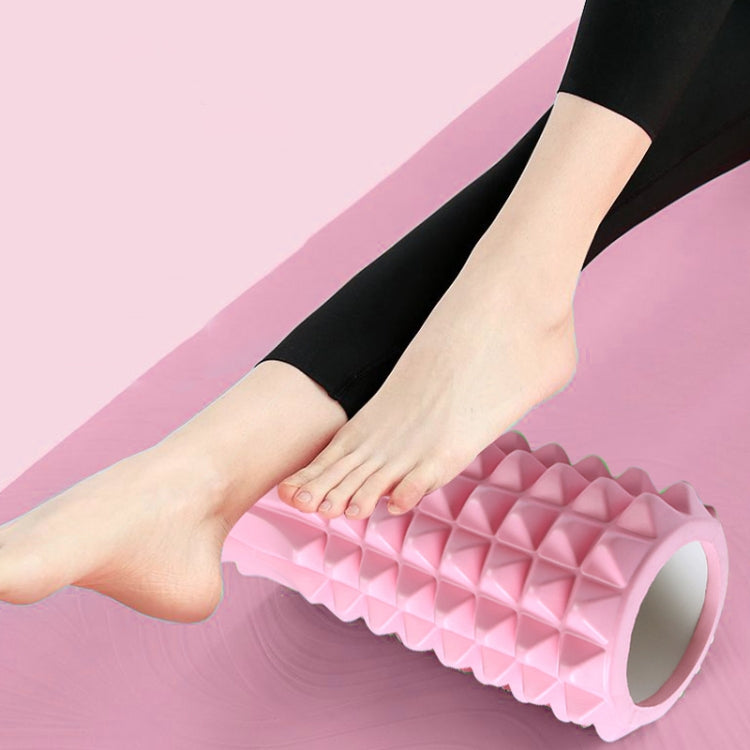 Pink EVA foam roller under foot, diamond bump texture for muscle relief