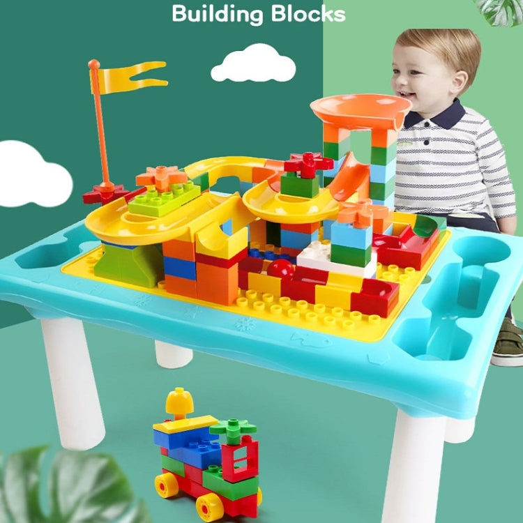 Kids' building table with colorful blocks on top; child playing beside the table