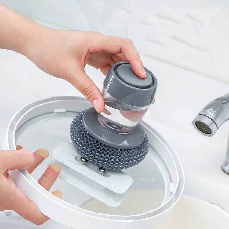 Dishwashing brush dispensing liquid while pressing the clear cup onto the scrub pad
