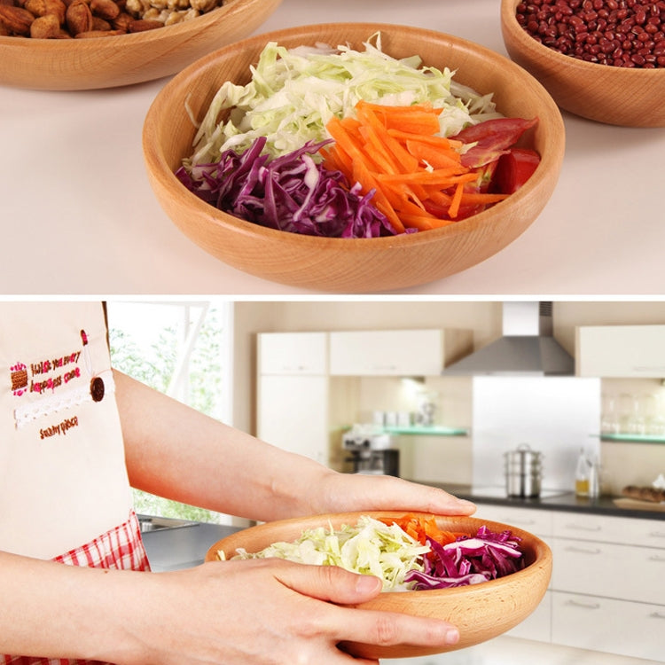 Round wooden salad bowl with shredded vegetables, held by hands