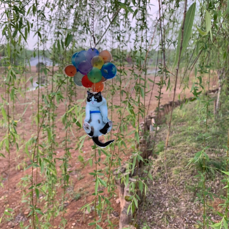 Cat balloon car pendant hanging outdoors in tall grass