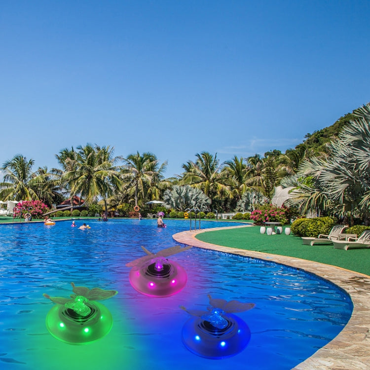 RGB solar floating lights on swimming pool water, colored glow on round disks