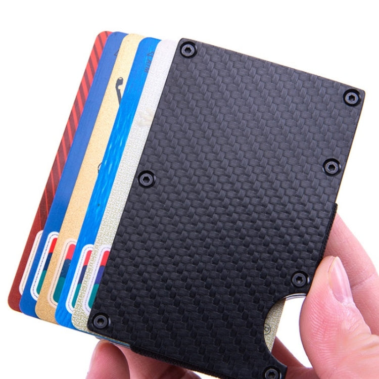 Carbon fiber card holder wallet holding several cards, textured gray surface