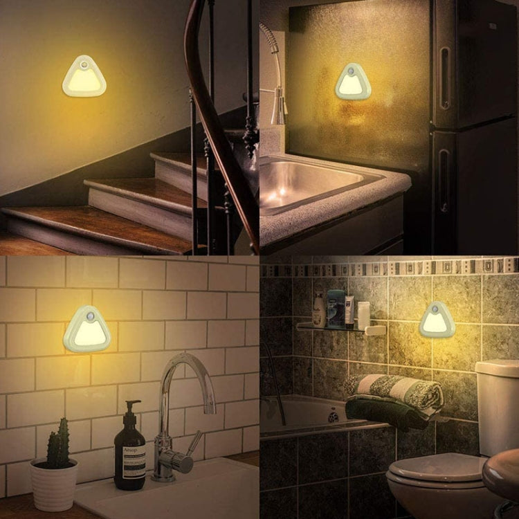 Multiple white triangular wall lamps with warm light in a bathroom setting
