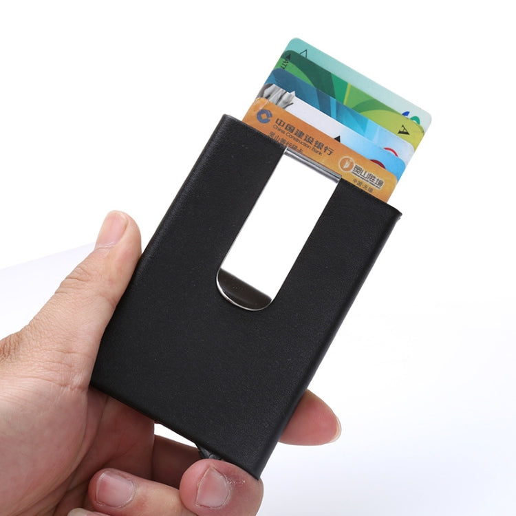 Black RFID credit card case held in hand with cards visible through slot